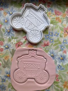 two cookie cutters sitting next to each other on top of a floral table cloth