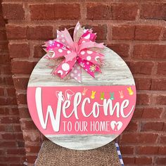 a welcome sign on the side of a brick wall with pink and white polka dots