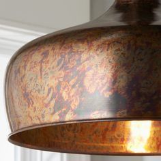 a close up of a light fixture with a brown pattered finish on the metal