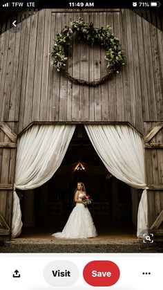 a bride standing in the doorway of a barn