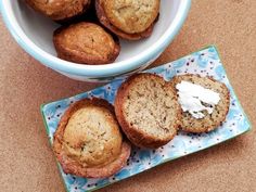 some muffins are sitting in a bowl and on a plate next to a cupcake