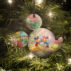 an ornament shaped like mickey and minnie mouse on a christmas tree with lights