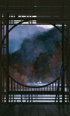 an open door with mountains in the background and foggy water on the other side