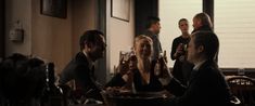 a group of people sitting around a table drinking beer