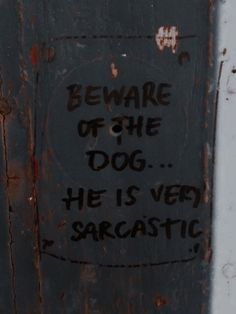 graffiti on the side of a door that says beware of the dog he is very sarcastic