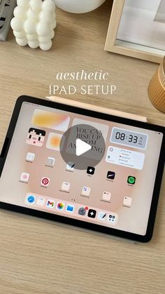 an ipad sitting on top of a wooden desk next to a clock and other items