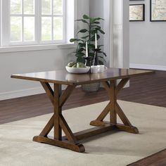 a wooden table with a potted plant sitting on it's top in front of a window