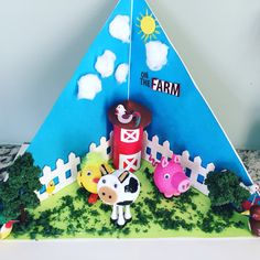 a cake that is shaped like a farm with animals and a barn in the background