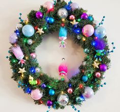 a christmas wreath with ornaments hanging from it