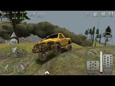 a yellow truck driving down a hill next to some trees and rocks with remote controls