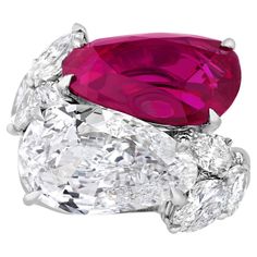 The exquisite 5.70-carat ruby and 4.54-carat diamond showcased in this bypass ring create a tantalizing interplay. The pear-shaped crimson gemstone is certified by the American Gemological Laboratories as being Burmese in origin and all natural, with no indications of thermal treatment to influence the stone's color. The rich red ruby exhibits the coveted hue for which the best Burma rubies are prized. Political unrest caused the closure of the mines in the early 1960s, making these gems exceedi Luxury Ruby Ring With Brilliant Cut Cubic Zirconia, Luxury Red Ruby Cubic Zirconia Ring, Luxury Brilliant Cut Ruby Ring With Cubic Zirconia, Luxury Round Cut Cubic Zirconia Ruby Ring, Luxury Garnet Ruby Ring With 17 Jewels, Luxury Ruby Ring With Accent Stones In Platinum, Luxury Platinum Ruby Ring With Accent Stones, Luxury Modern Ruby Ring With Gemstone, Luxury Ruby Ring With Brilliant Cut And Round Band