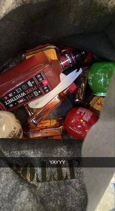 a bag full of liquor bottles sitting on top of a floor next to an apple