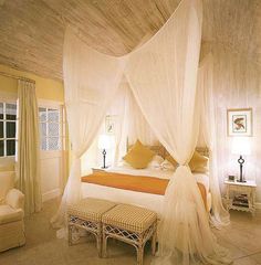 a bedroom with a canopy bed and white curtains