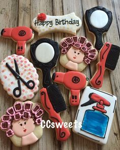 decorated cookies are arranged in the shape of hairdryers, scissors and combs