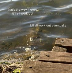 a wooden dock sitting in the middle of a lake next to a body of water