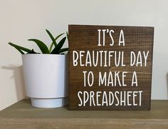 a wooden sign that says it's a beautiful day to make a spreadsheet