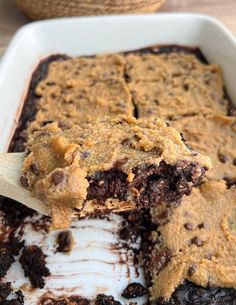 a scoop of ice cream is being lifted from a pan filled with chocolate chip cookie bars