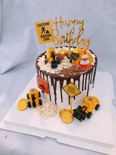 a birthday cake is decorated with construction themed frosting and yellow caution signs on top