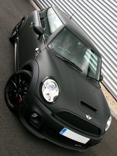 a black sports car parked in front of a building