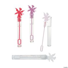 three toothbrushes with pink and purple designs on them next to an empty tube