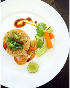 a white plate topped with rice, shrimp and veggies