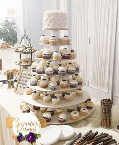 a wedding cake and cupcakes on a table