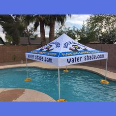 a large blue and white tent sitting next to a pool with yellow rubber ducks floating in it