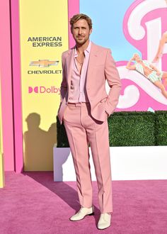 a man in a pink suit and white shoes at the american express awards red carpet