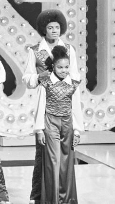 an old photo of two children on stage with one holding the other's arm