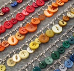 many different colored buttons are hanging from chains