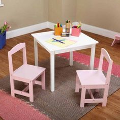 two children's wooden chairs sitting at a white table in a child's playroom