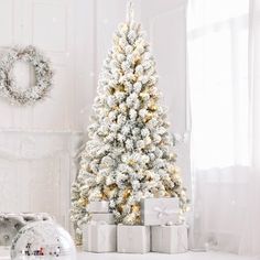 a white christmas tree with presents in front of it