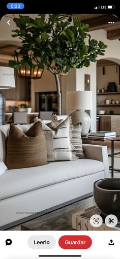 a living room filled with furniture and a tree in the middle of it's center