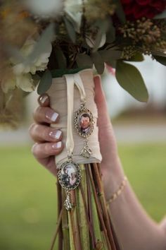 a woman holding a bouquet of flowers in her hands with pictures attached to the stems