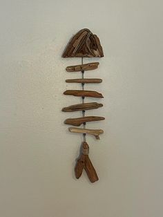 a clock made out of wood sticks and other items hanging from the side of a wall