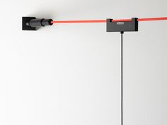 two black and red lights hanging from the side of a wall