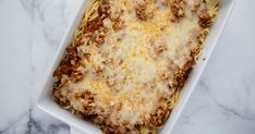 a casserole dish with meat and cheese in it on a marble counter top