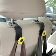 two sunflowers are attached to the back seat of a car with black straps