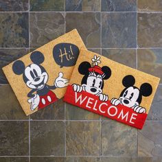 two mickey mouse welcome mats on a tile floor