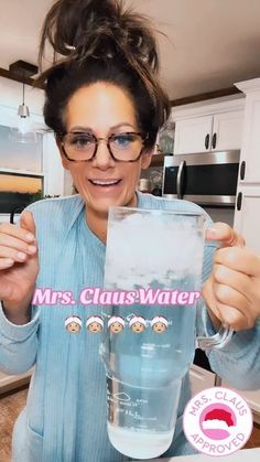 a woman is holding up a water pitcher