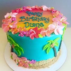 a birthday cake decorated with flowers and palm trees