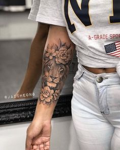 a woman with a lion tattoo on her arm