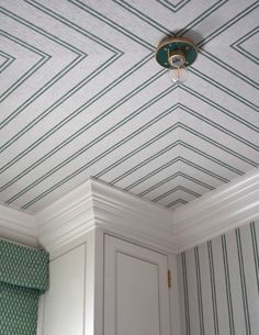 the ceiling is decorated with green and white striped wallpaper, along with a light fixture