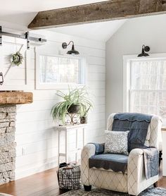 a living room filled with furniture and a fire place next to a window on top of a hard wood floor