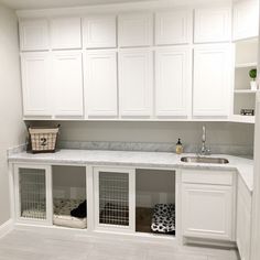 a kitchen with white cabinetry and marble counter tops is pictured in this image the cabinets are all white