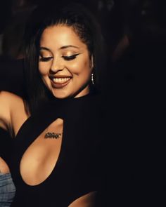 a woman in a black top smiling at the camera