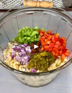 a bowl filled with pasta and vegetables on top of a table