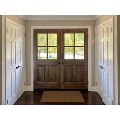 two wooden doors are open on the inside of a house with wood floors and white walls