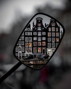 a mirror with some buildings reflected in it