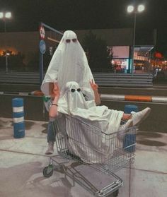 a man in a ghost costume sitting in a shopping cart